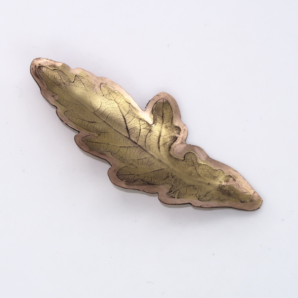 Gold plated impression of an oak leaf in copper