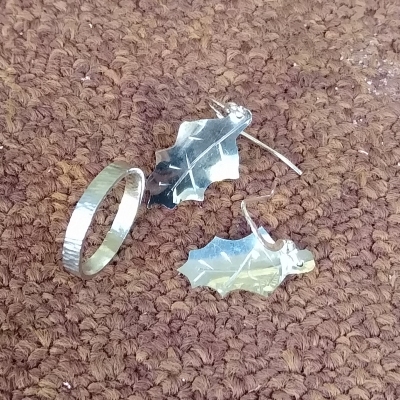A silver ring and a pair of holly leaf earrings